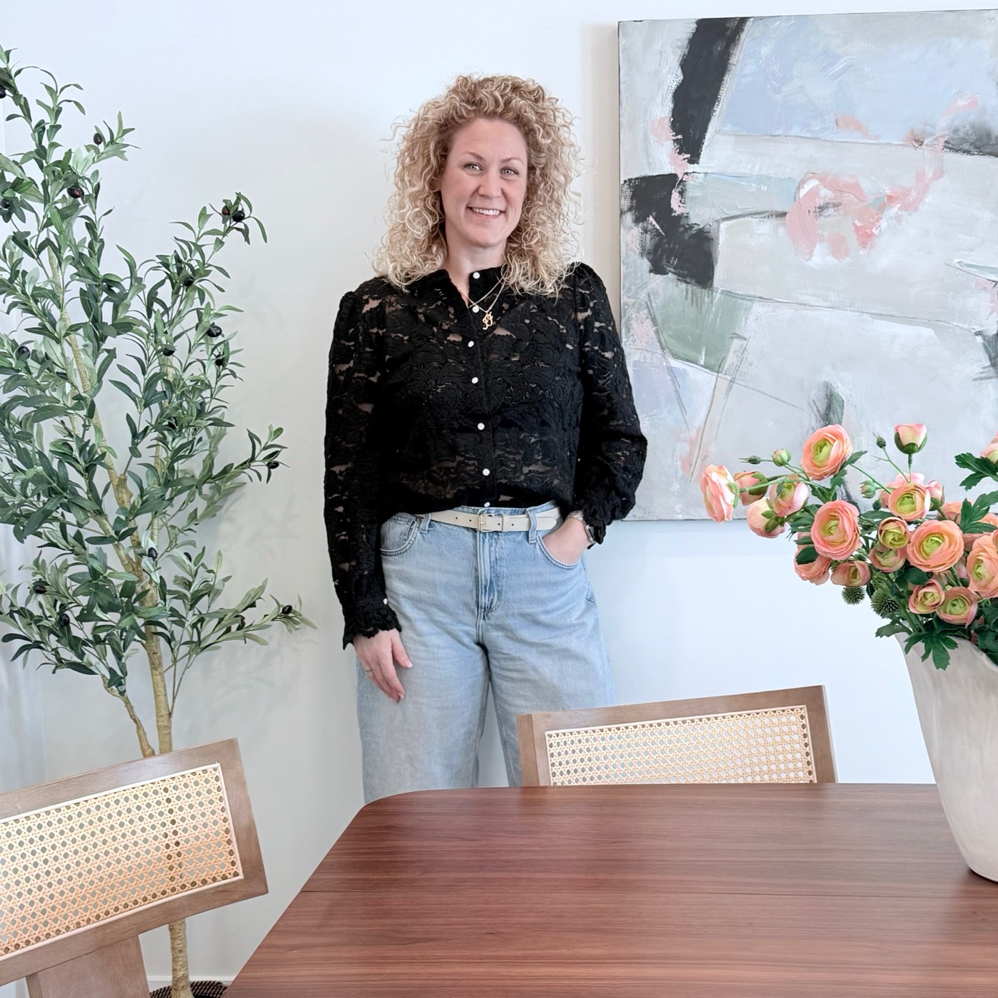 Aimée Lauren Leslie, owner and lead interior stylist, standing beside one of her original paintings