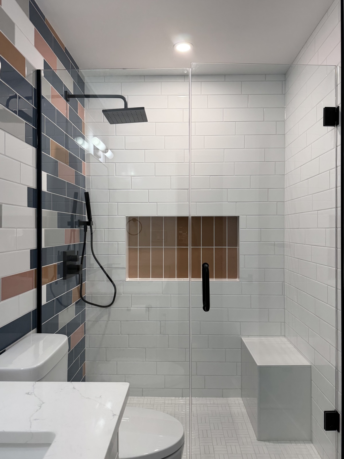 Renovated bathroom with glass walk-in shower and multicolour tile feature wall, from the Aimee Lauren Interiors portfolio